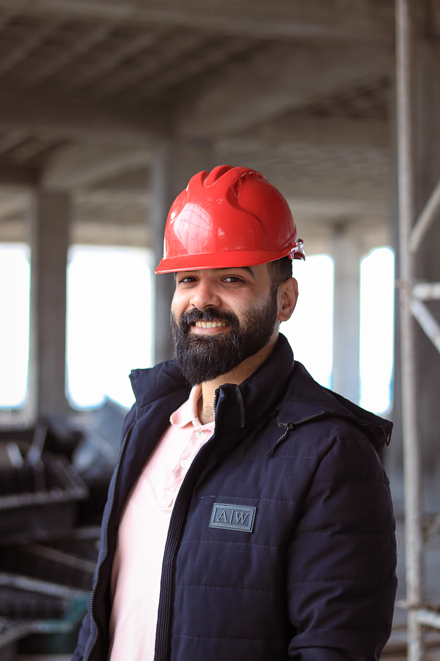 Site manager in a red hard hat inside a building under construction