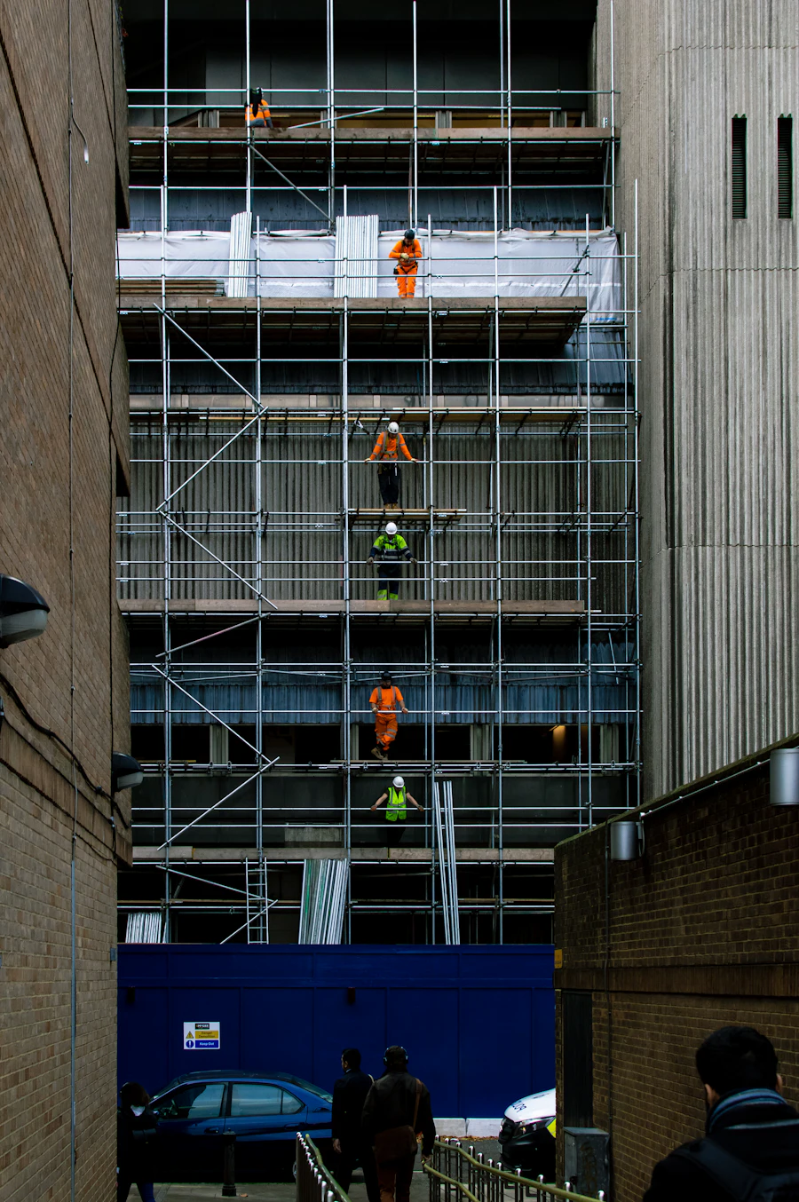 Workers on scaffolding across a tall building facade