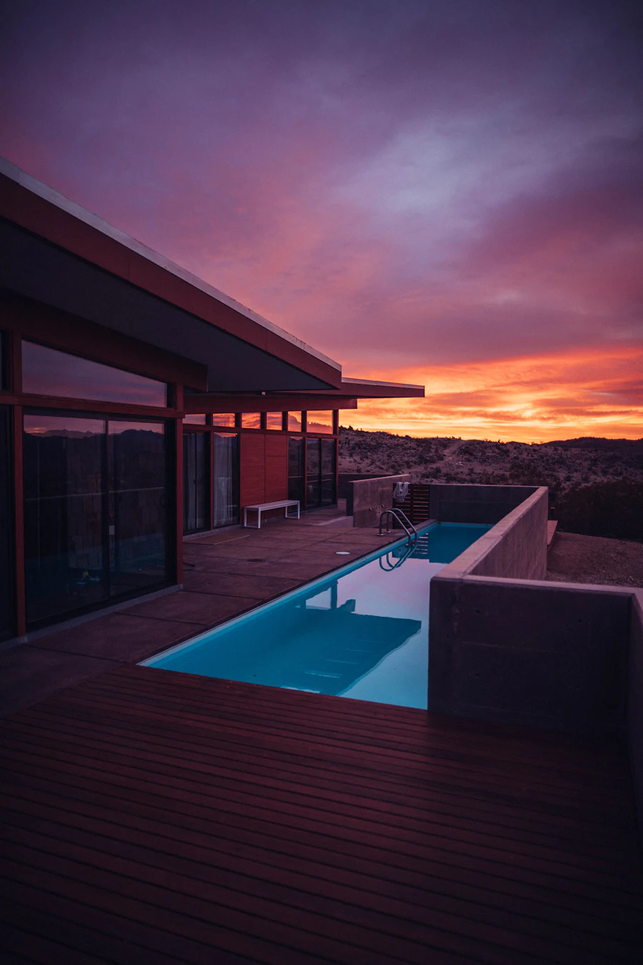 Rooftop pool terrace of a modern house beneath a purple dusk sky