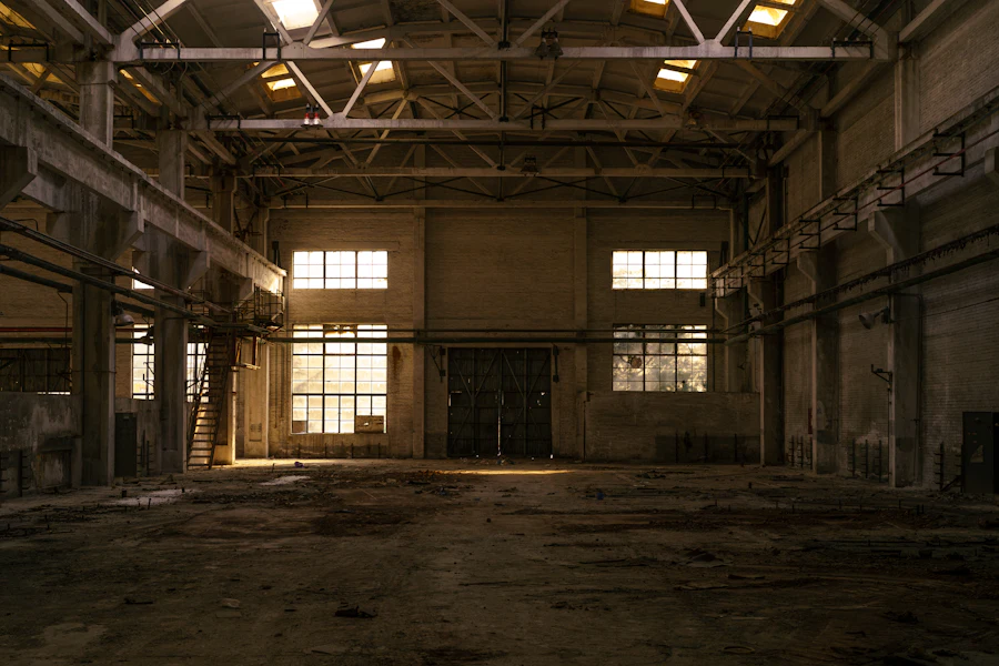 Vast steel-framed industrial hall with tall windows and warm light